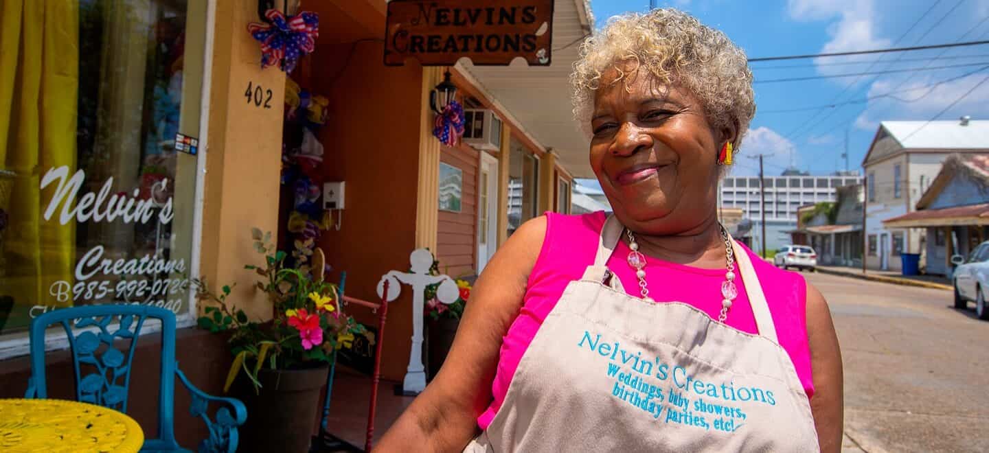 Nelvin, a loyal customer, stands proud outside of her shop.