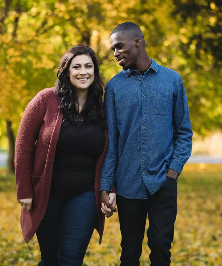 Happy couple standing together holding hands.